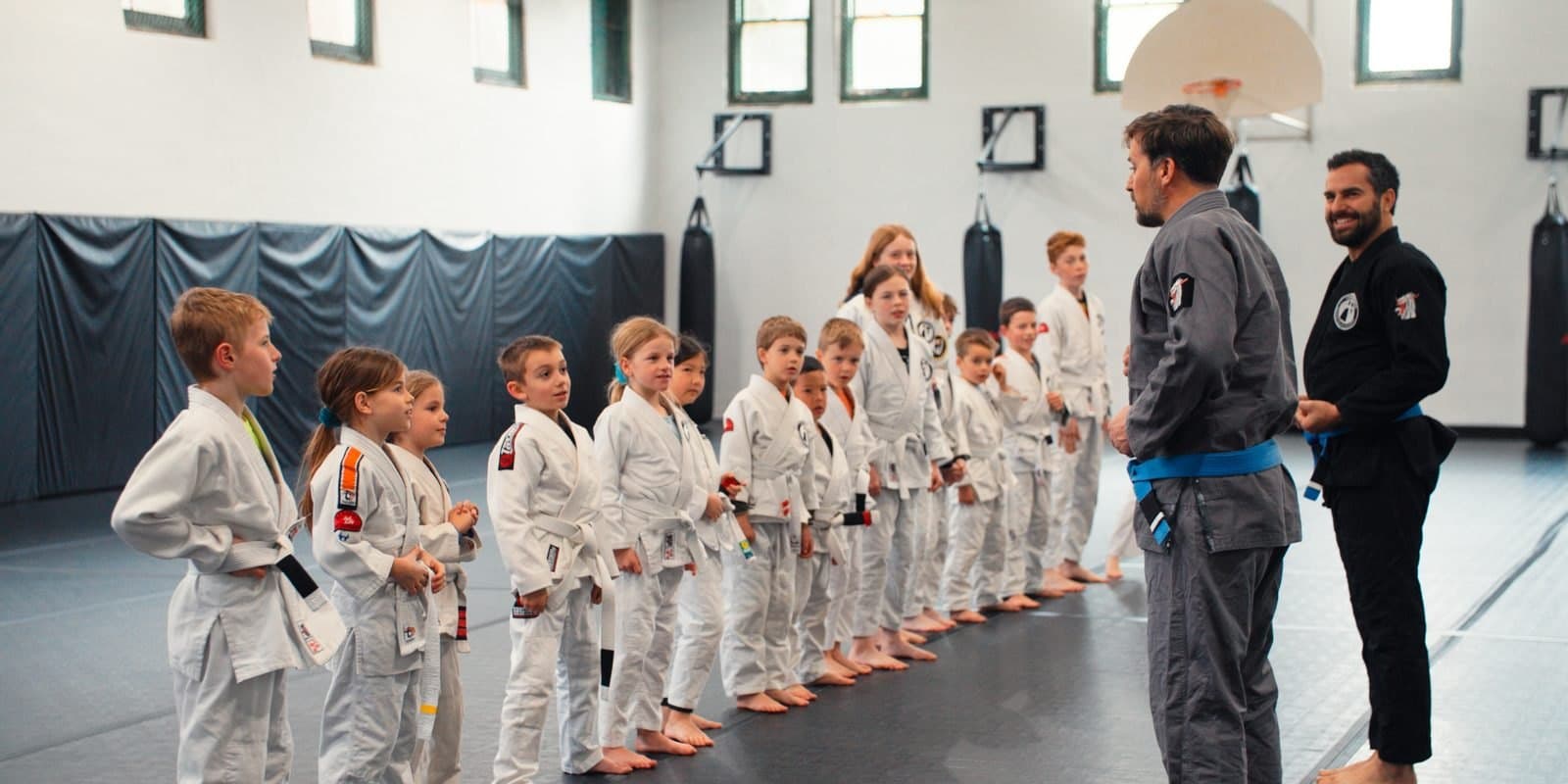 Kids BJJ class lined up to receive instruction from coaches