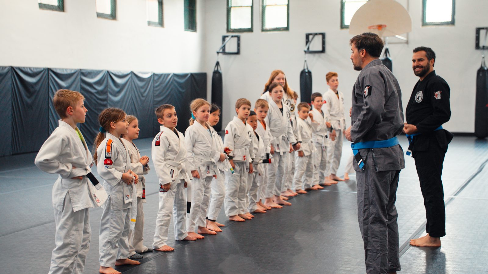 Kids BJJ class lined up to receive instruction from coaches