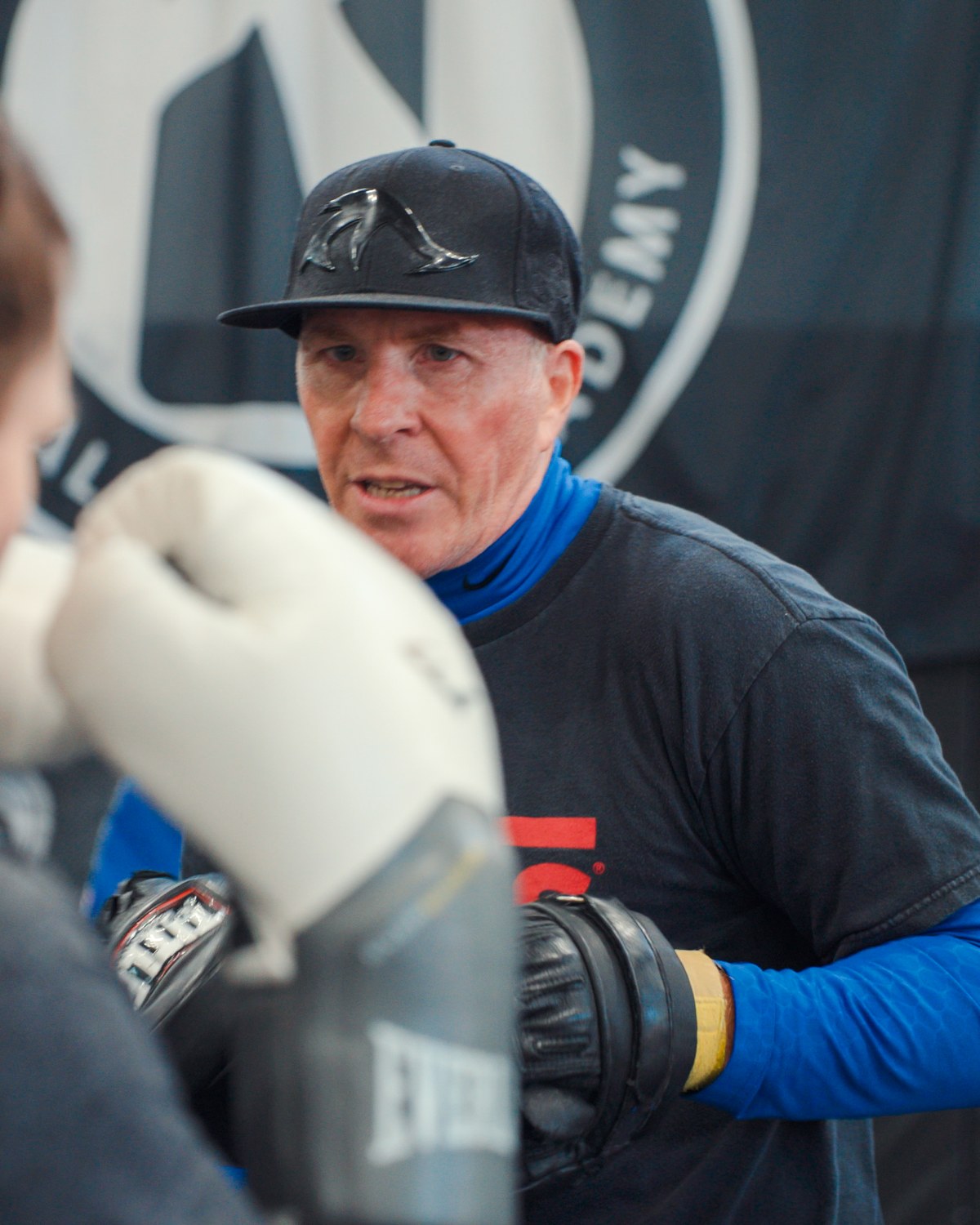 Gary Hynd — boxing coach at Crossroads Martial Arts, working pads with a student